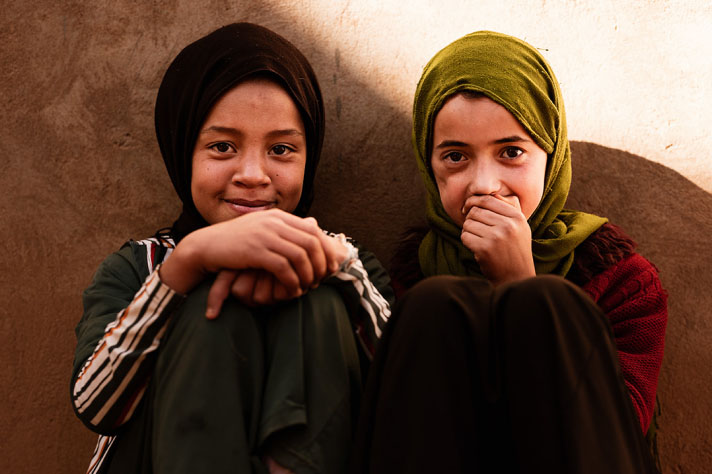 Two Moroccan girls standing in front of a wall