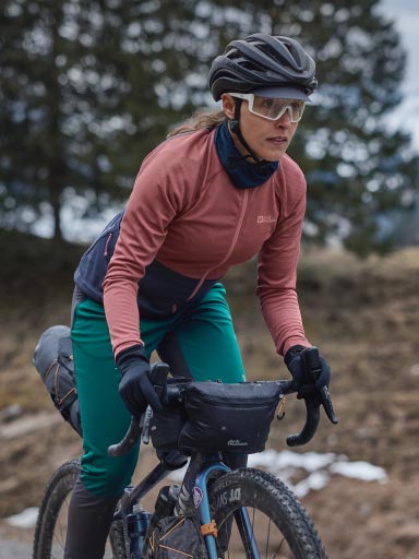 Man in a cycling jersey takes a drinking bottle out of his bum bag